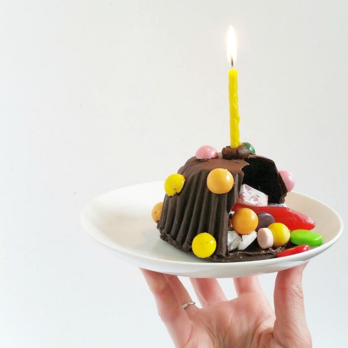 mini-gateau-anniversaire-chocolat-façon-pinata-aux-smarties-et-bonbons-gélifiés-bougie-jaune mini-gateau pinata creux au chocolat qui renferme des confiseries variées, avec une seule bougie