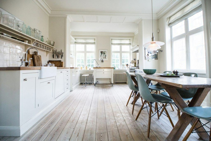parquet gris, placards blancs, grande table en bois, chaises design scandinave, suspension blanche, grandes fenêtres