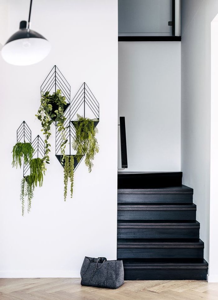 un escalier peint intégralement en noir pour un effet de profondeur, déco cage d'escalier d'esprit scandinave avec des porte-plantes en acier noir