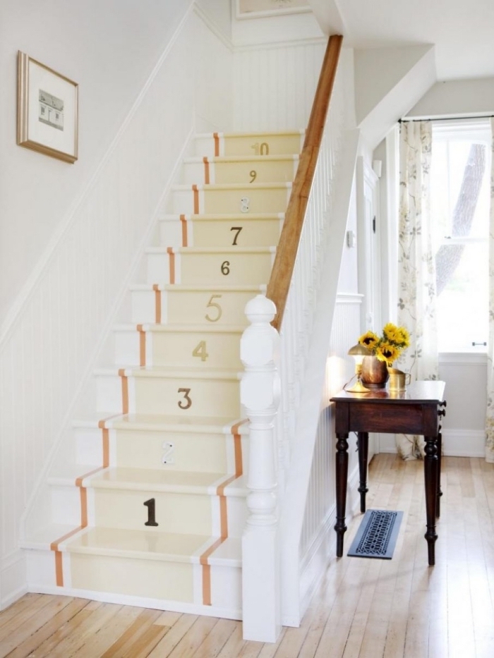 comment peindre un escalier de façon originale, des bandes de peinture orange et jaune pâle avec des chiffres au pochoir pour un effet de peinture tapis d'escalier