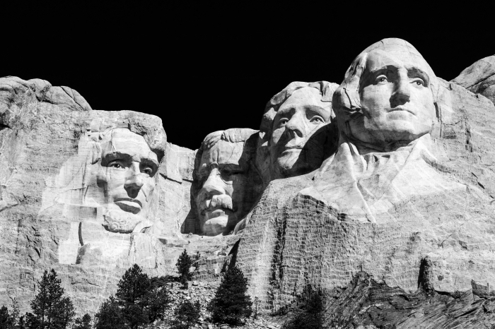 image noir et blanc de mont rushmore avec ses quatre présidents sculptés dans le rocher, se détachant sur le fond noir du ciel