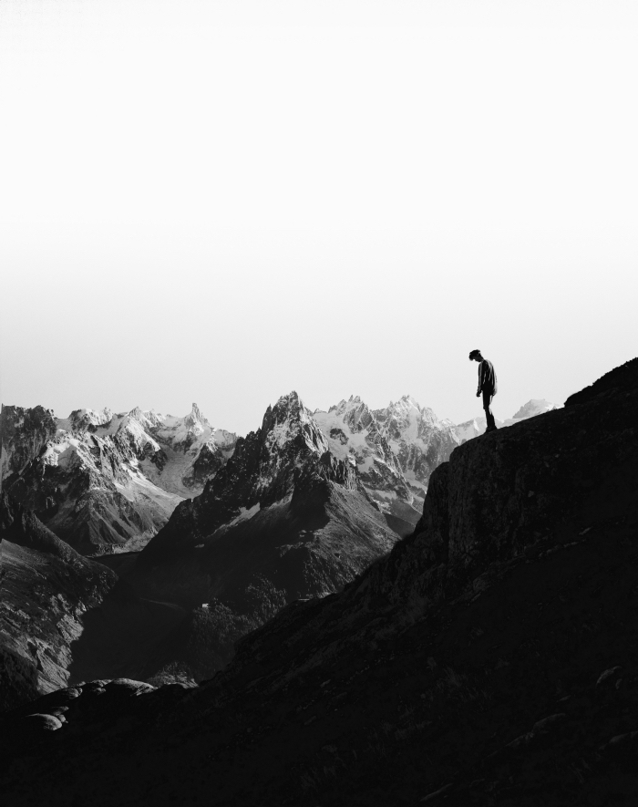 portrait noir et blanc l'homme et la montagne, photo en noir et blanc de silhouette d'un homme monté au sommet de la montagne