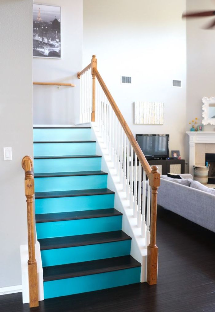 un dégradé de bleu sarcelle sur les contremarches de l'escalier en contraste avec le bois laqué foncé, qui donner de la profondeur à la cage d'escalier