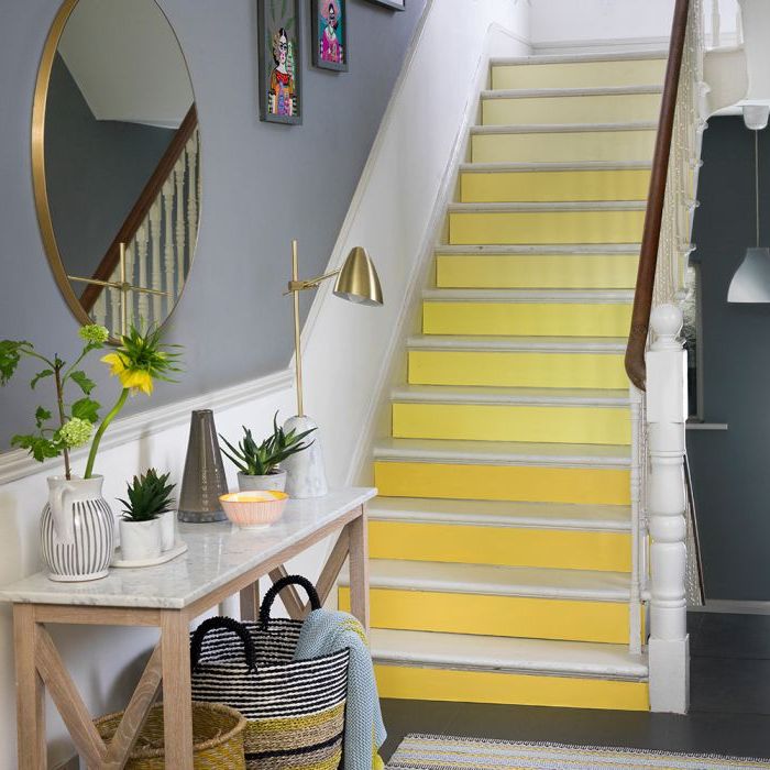 renovation escalier bois, escalier aux contremarches en dégradé de jaune qui illuminent l'entrée couleur bleue grise et s'harmonisent avec les accents déco en laiton