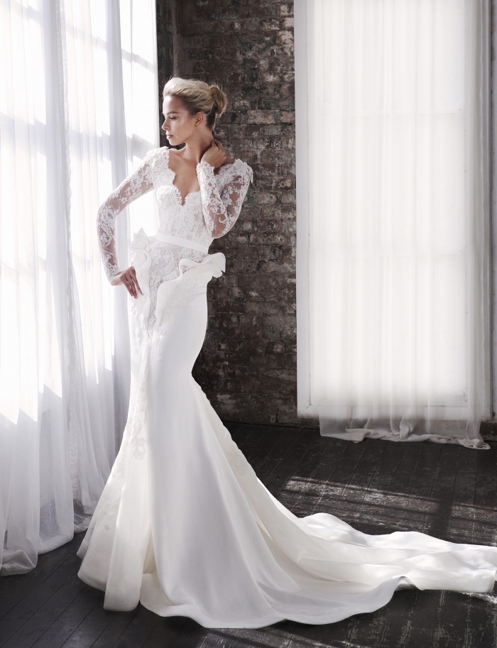 robe-de-mariée-sirène-collection-de-stevenkhalil-décolleté-plongeant-manches-avec-fleurs-brodées-coiffure-cheveux-en-chignon-ceinture-fine-traîne modèle splendide tenue de mariage femme, robe de mariée originale à design sirène avec longue traîne et décolleté