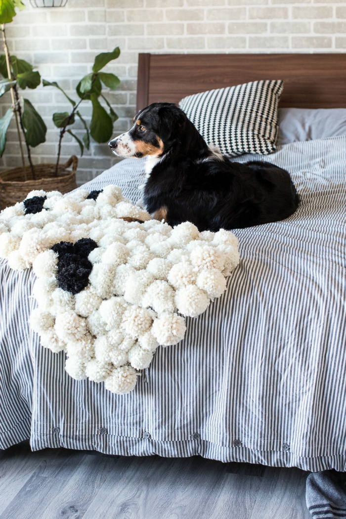 tapis de lit pompons, couette de lit rayures, cache-pot de fleur tressé, tête de lit en bois, grand chien