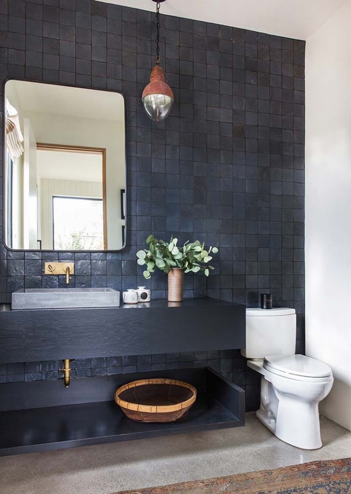 un mur d'accent en carrelage zellige noir accordé avec le plan vasque noir pour une ambiance élégante et authentique