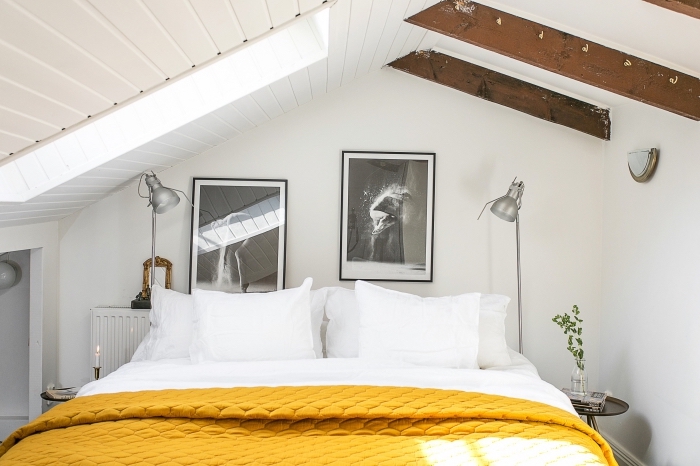 objets décoration de couleur ocre, chambre sous pente aux murs blancs, cadre noir avec photo blanc noir, modèle couverture de lit jaune moutarde