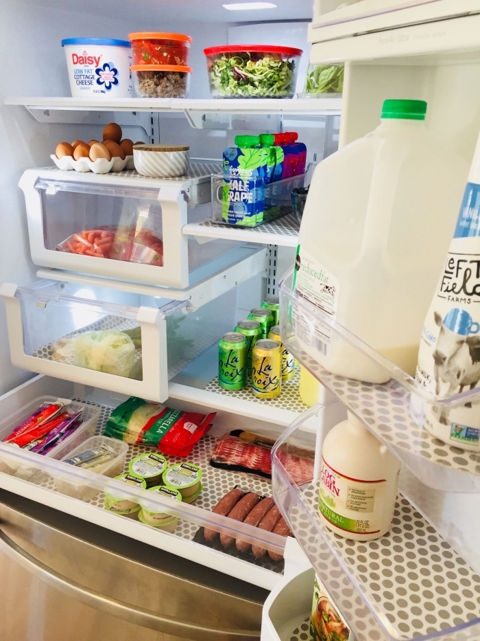 une bonne organisation frigo avec des aliments rangés aux bons endroits, tapis de réfrigérateur anti-bactériens placés sur les tablettes et des tiroirs 