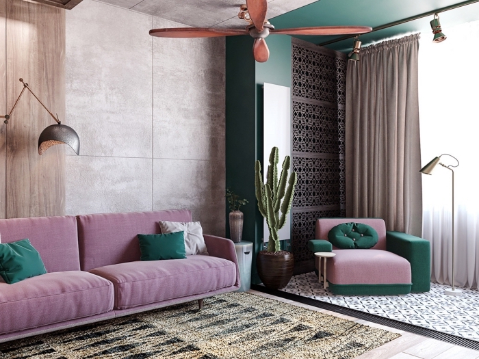 modèle de canapé rose décoré avec coussins de couleur vert pin, revêtement mural en panneau bois, tapis beige et noir aux motifs géométriques