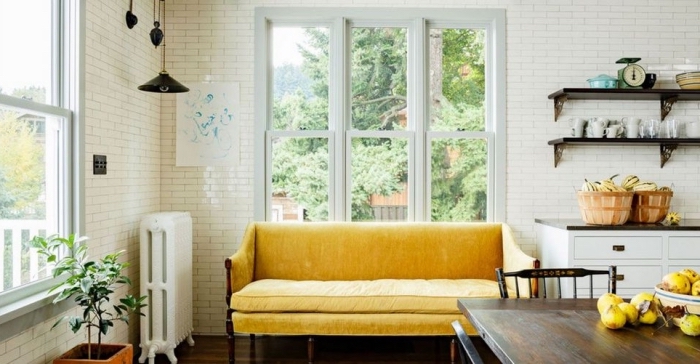 style campagne dans une cuisine blanche aménagée avec meubles bois foncé, modèle de canapé jaune moutarde et bois foncé