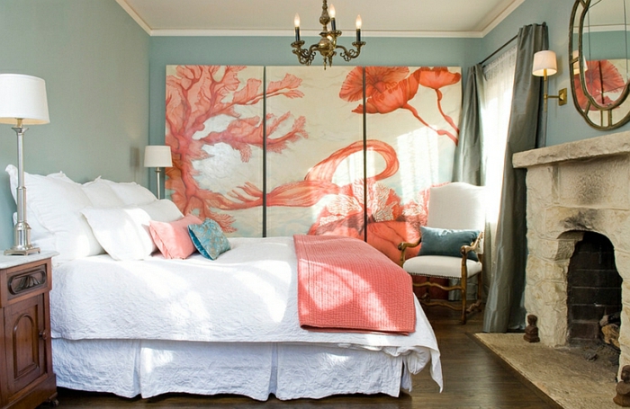chambre à coucher avec cheminée, grand lit blanc, chandelier, mural décoratif, grand panneau abstrait