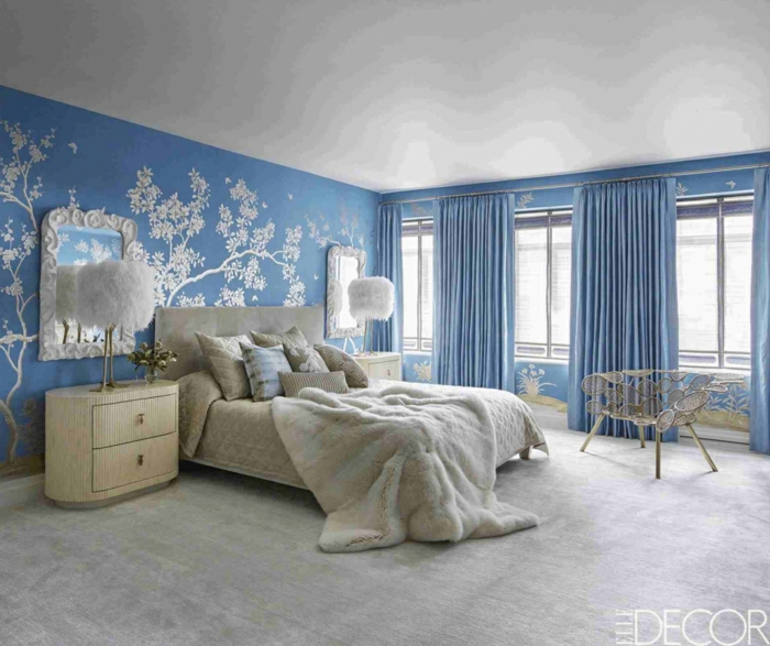 chambre adulte plongée dans le bleu et le blanc, petites commodes de chevet blanches, lampes à plumes, tapis gris, miroirs blancs