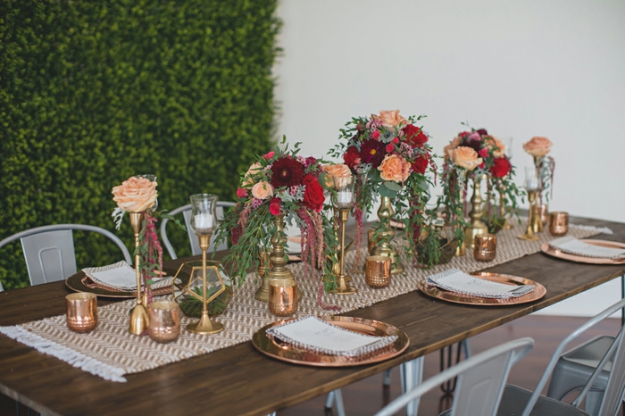 table en bois, chemin de table tissu, bougeoirs dorés, bouquets de roses, chaises design industriel
