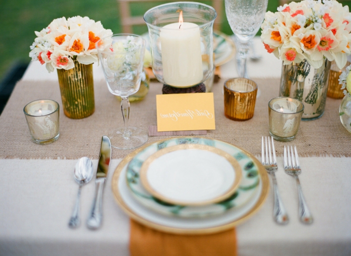 comment décorer la table de mariage, assiettes superposées, petits bouquets de jonquilles, chemin de table tissu, bougeoirs dorés