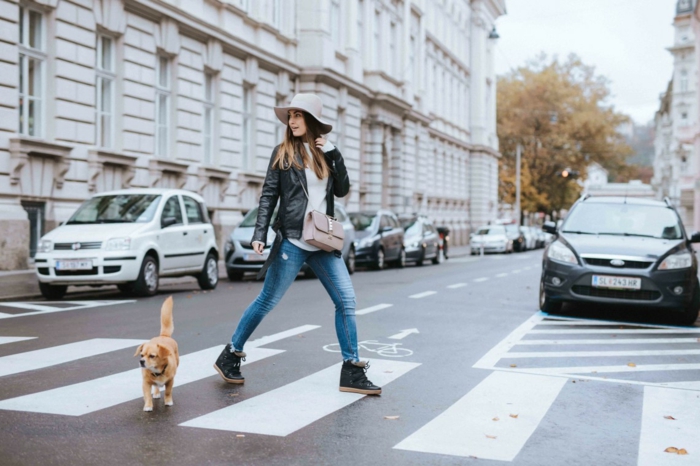 Femme avec sin chien sur un passage piéton, jean et veste cuir, voitures parqués sur la rue, marque vetement femme, look tumblr, photo tumblr fille moderne 