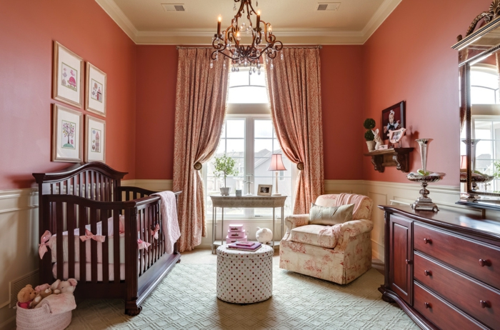 chambre d'enfant, petite table basse, lit bébé en bois foncé, chandelier, fauteuil floral, buffet bois, grand miroir encadré