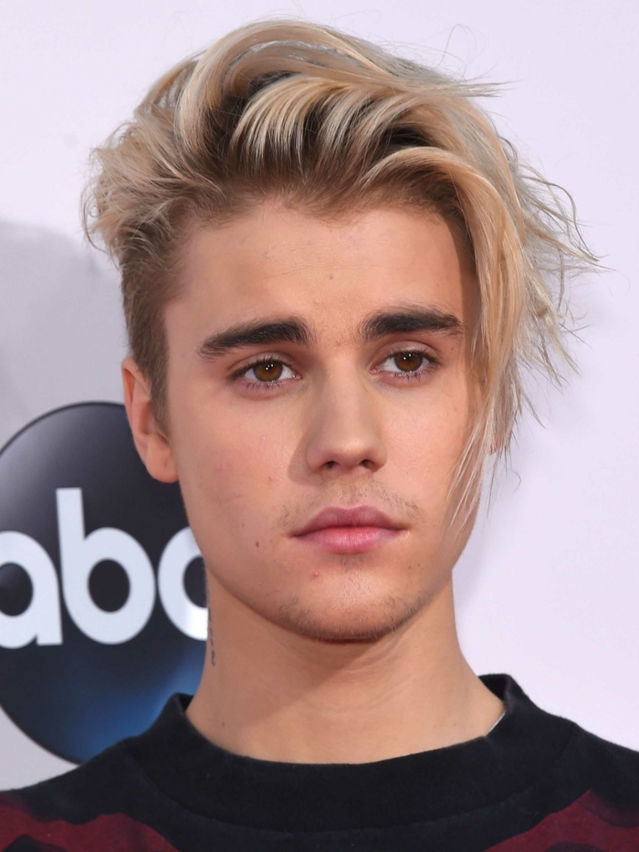 Justin Bieber, cheveux blonds, yeux couleur noisette, frange mise de côté volumineuse