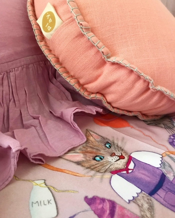 coussin rose, draperie lilas, chat dessiné au tissu, ballon orange, déco d'intérieur avec couleur saumon