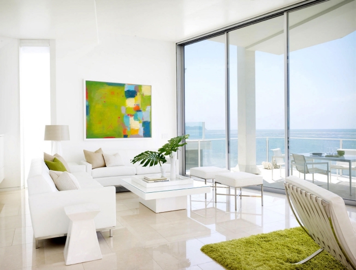 salon blanc avec grandes fenêtres au plafond blanc et plancher de carrelage beige, accents de couleur vert anis