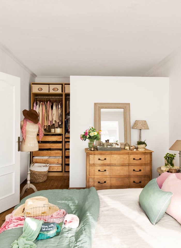 dressing ouvert aménagé comme un espace distinct dans la chambre à coucher grâce à une cloison, équipé de penderie ouverte en bois qui s'accorde avec la commode vintage
