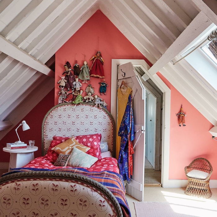 chambre attique, poutres apparentes blanches, table de chevet blanche, chaise tressée, poupées de chiffon accrochées au mur
