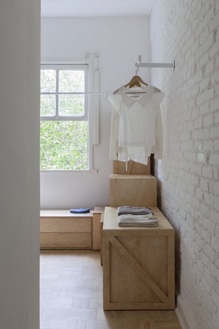 fabriquer un dressing récup à partir des caisses en bois empilées, une pièce en dressing avec un pan de mur en briques blanches