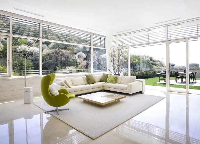 comment décorer un salon spacieux en blanc, modèle de grand canapé d'angle blanc décoré avec coussins de nuances vertes