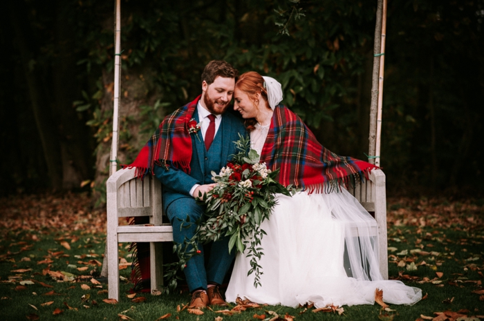 mariage traditionnel, mariés assis sur une banquette blanche, chaussures homme haut de gamme, couverture carré écossais