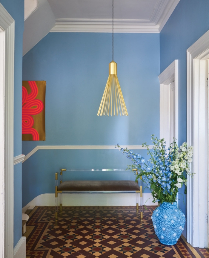 idée déco couloir aux murs peints en couleur bleu clair lumineux mise en valeur par quelques accents dorés et par le carrelage céramique en tons terre
