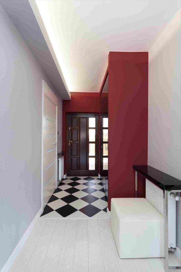 couloir rouge, blanc et gris clair au sol vinyle imitation damier noir et blanc