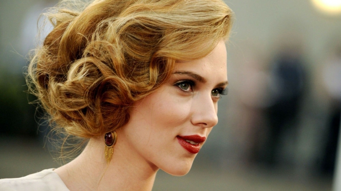 coiffure chignon flou de côté, grands boucles sur cheveux blonds, boucles d'oreille vintae, Scarlett Johansson