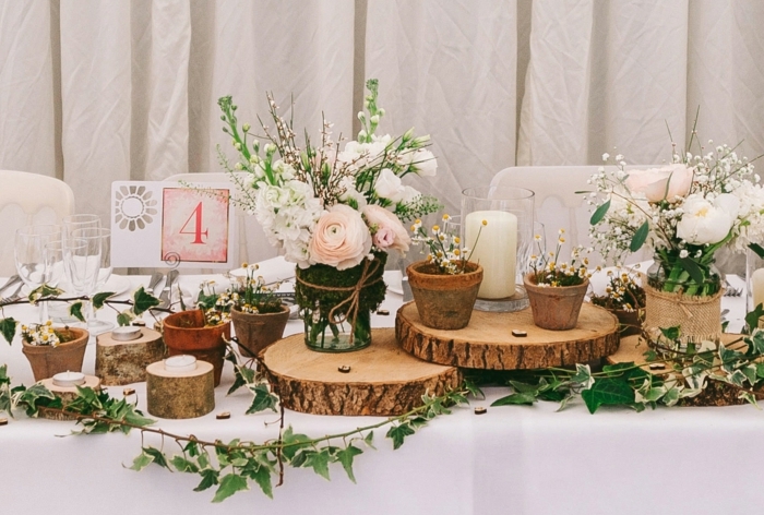 rondins de bois pour chemin de table mariage, petits pots de fleurs, bouquets romantiques, nappe de table blanche