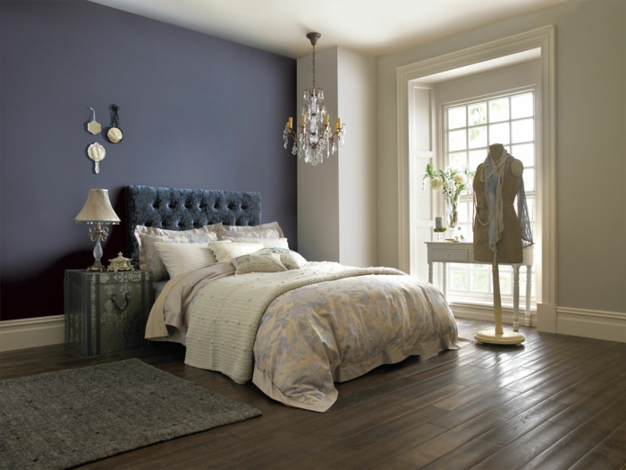 chambre féminine, tête de lit gris anthracite, sol en bois, chandelier en cristal, porte-manteau mannequin, tapis gris