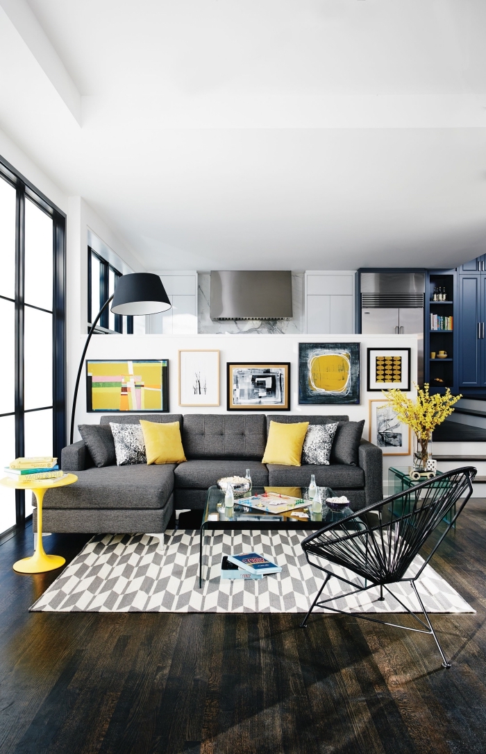idée déco de salon gris et jaune, pièce blanche avec meubles foncés et accents jaune, mur de cadres dans le salon