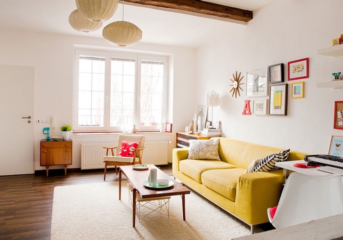 déco cozy dans un salon blanc avec parquet foncé, modèle de tapis moelleux blanc, modèle canapé jaune avec coussins