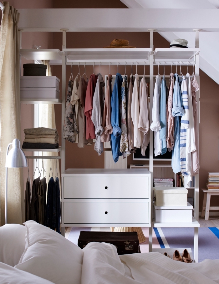 une penderie ouverte près du lit qui sépare la chambre en deux espaces distincts, système de rangement pour vêtement ikea