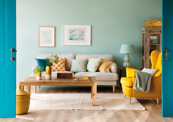 idée deco jaune moutarde avec accessoires ou meubles modernes, salon aux murs vert pastel avec parquet bois clair et accents en couleurs