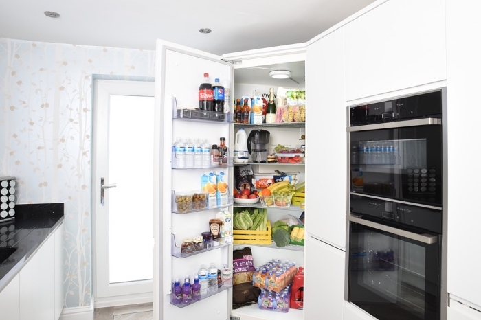 comment bien organiser son frigo, intérieur d'un réfrigérateur encastré bien rangé avec des étagères 