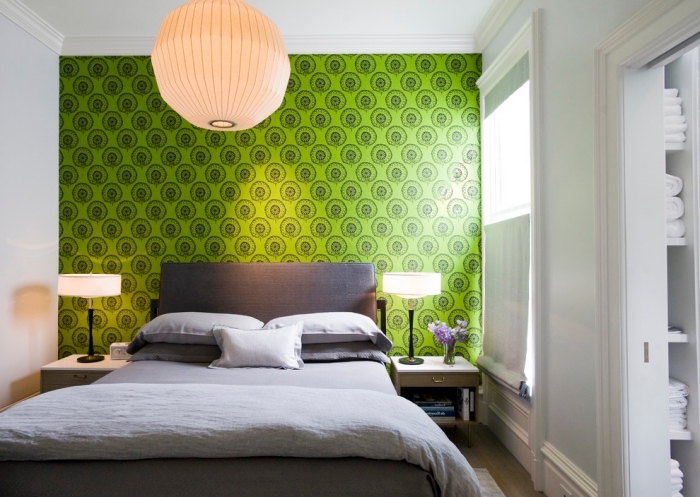design petite chambre aux murs blancs avec pan de mur en papier peint de couleur vert anis, modèle grand lit gris anthracite