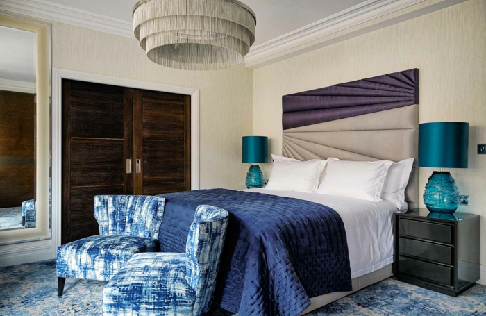 peinture chambre adulte deux couleurs, deux fauteuils bleus, plafonnier, deux chevets en bois, tête de lit bicolore
