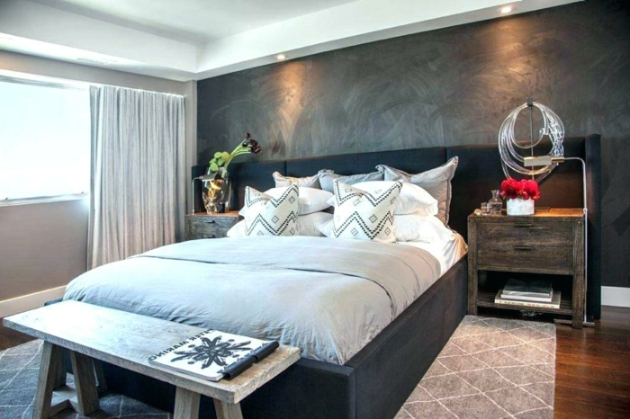 chambre en gris et blanc, lit gris anthracite, banquette en bois, tapis motifs géométriques, mur gris anthracite, sol en bois