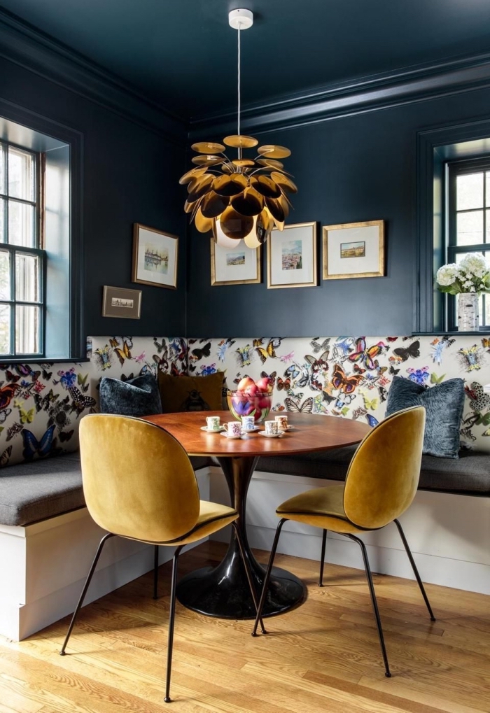 chaise métal avec siège de couleur ocre, peinture foncée pour murs dans un salon ou salle à séjour, lampe suspendue finition dorée