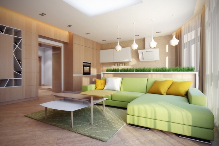 déco de salon aux murs bois ouvert vers la cuisine, modèle de canapé d'angle de couleur vert amande avec coussins moutarde