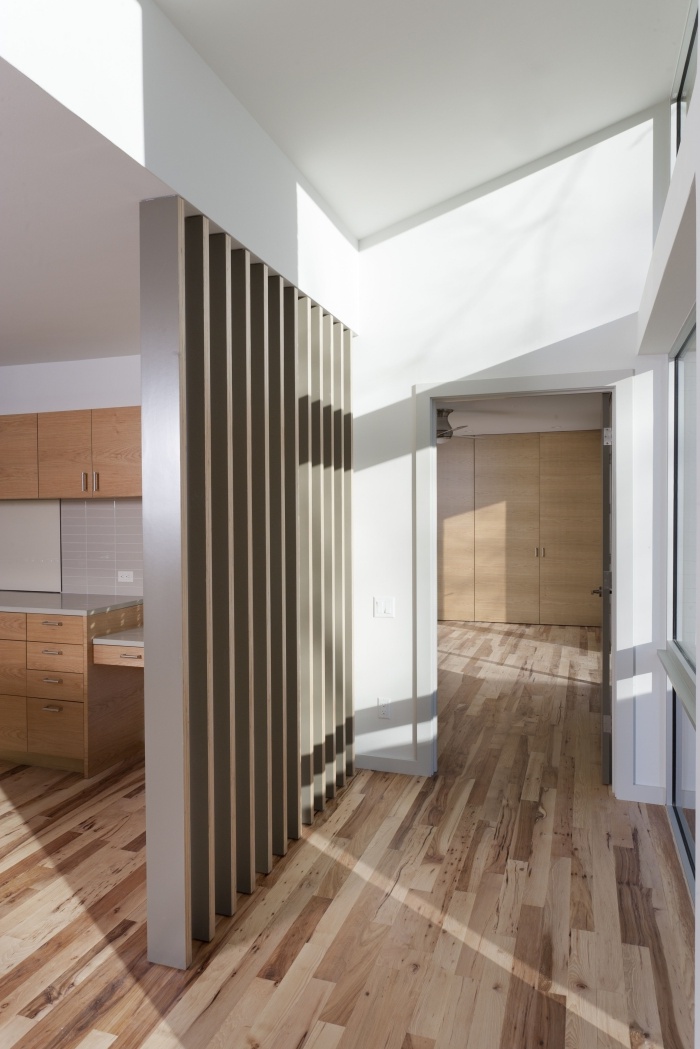 design intérieur moderne dans une cuisine ouverte aux murs blancs avec plancher et meubles en bois
