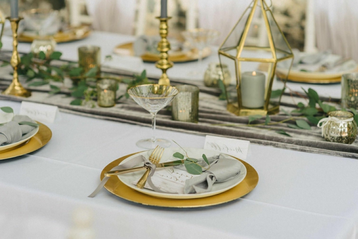 deco table mariage, chemin de table gris, sous-assiettes dorés, assiettes blanches, bougeoirs en verre et métal doré, 