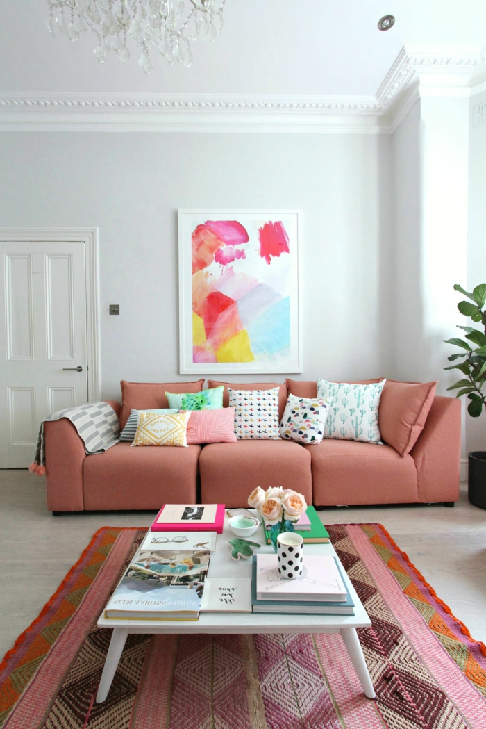 grand sofa couleur saumon, tapis ethnique, table blanche, plafonnier pampille, plante décorative, tableau peinture abstraite