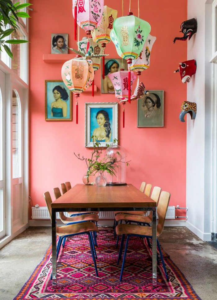 mur en couleur pantone année 2019, grande table à manger, lanternes japonaises suspendues, tapis ethnique pourpre, plusieurs portraits accrochés au mur