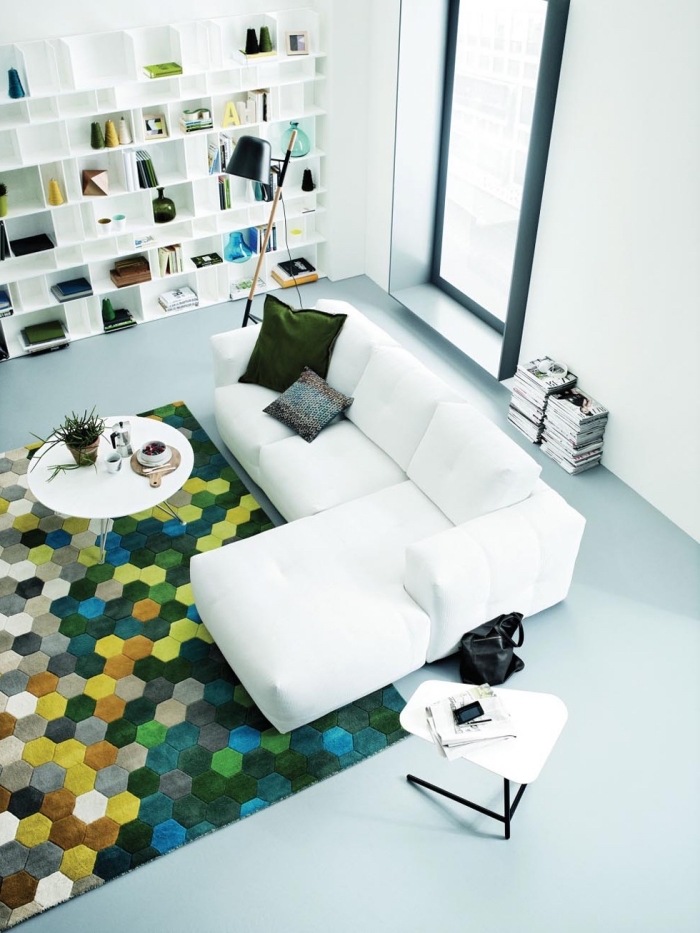 aménagement salon au plafond haut blanc avec meubles bois blanc et canapé d'angle blanc, coussin de couleur vert sapin