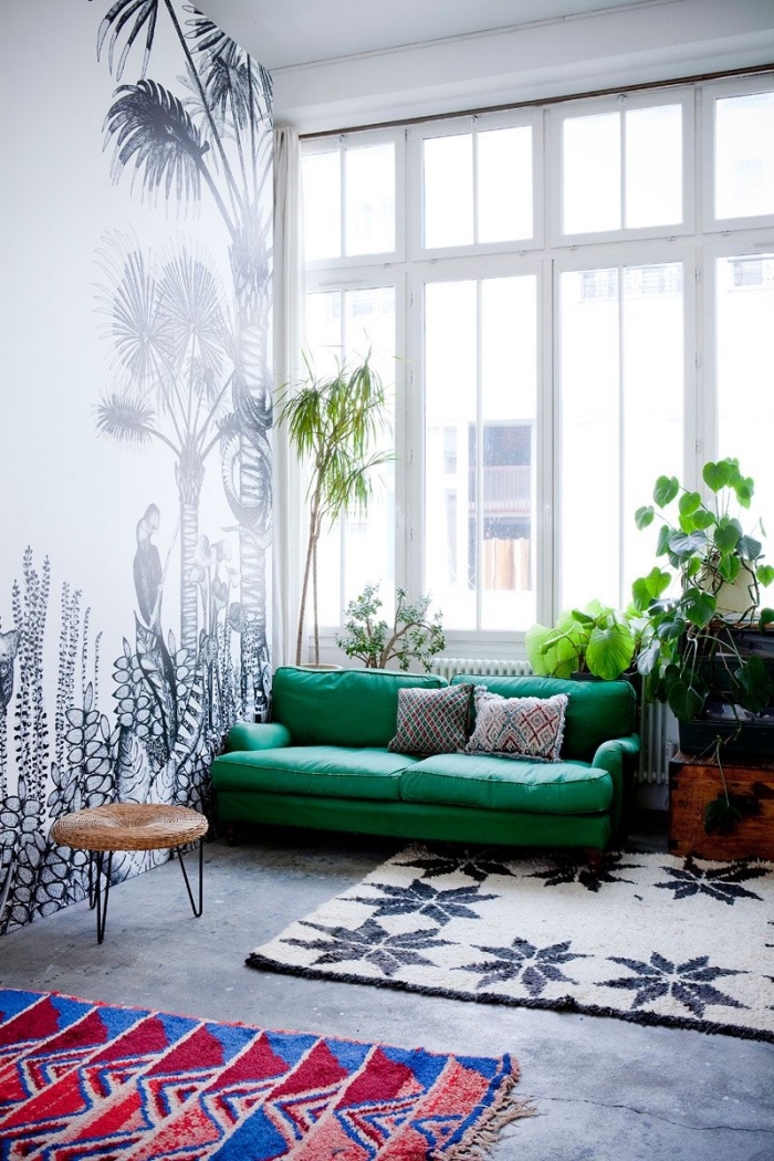 modèle de canapé salon de couleur vert emeraude décoré avec coussins gris, revêtement mural en papier peint blanc et noir